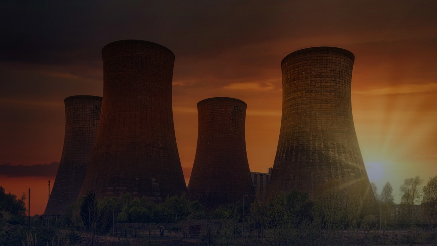 Nuclear power plant cooling towers at sunset representing India nuclear energy growth and clean power investment.