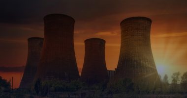 Nuclear power plant cooling towers at sunset representing India nuclear energy growth and clean power investment.